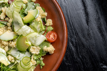 Green salad with couscous, avocado and tomato.