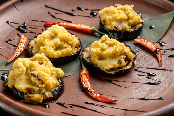Pumpkin puree is laid out on grilled eggplant.