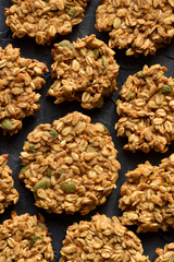 Healthy vegan food. Ugly homemade pumpkin oatmeal breakfast cookies with seeds on black background