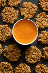 Healthy vegeterian food. Gluten free homemade pumpkin oatmeal breakfast cookies with seeds and pumpkin puree on black background
