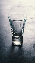 Empty vodka glasses on black concrete background