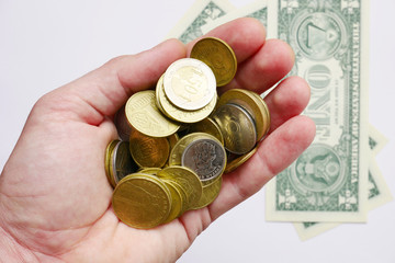 Coins of Ukraine and US dollar. Exchange office. Coins in the hand.