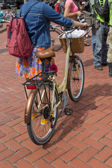 A woman with a backpack on a bike. Back view