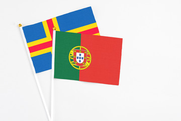 Portugal and Aland Islands stick flags on white background. High quality fabric, miniature national flag. Peaceful global concept.White floor for copy space.