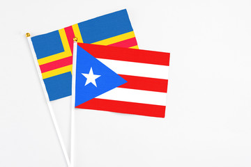 Puerto Rico and Aland Islands stick flags on white background. High quality fabric, miniature national flag. Peaceful global concept.White floor for copy space.