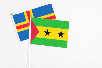 Sao Tome And Principe and Aland Islands stick flags on white background. High quality fabric, miniature national flag. Peaceful global concept.White floor for copy space.