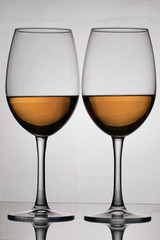 Wine glass goblets on a long leg. They stand nearby. They have a small amount of alcohol.