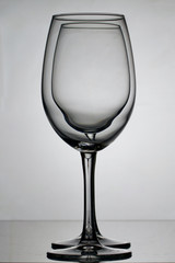 Wine glass goblets on a long leg. Two glasses to the light, one by one.