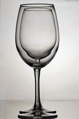 Wine glass goblets on a long leg. Two glasses to the light, one by one.