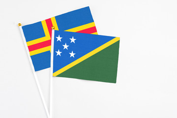 Solomon Islands and Aland Islands stick flags on white background. High quality fabric, miniature...