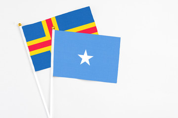 Somalia and Aland Islands stick flags on white background. High quality fabric, miniature national flag. Peaceful global concept.White floor for copy space.