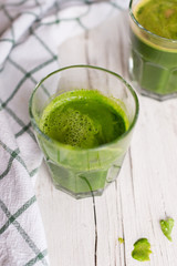 glass of green juice on wooden table