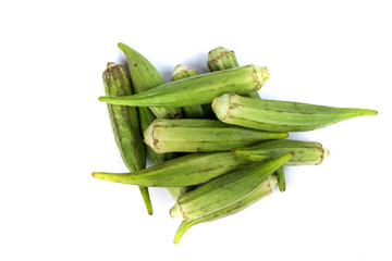 Pile of raw whole okra on a white background