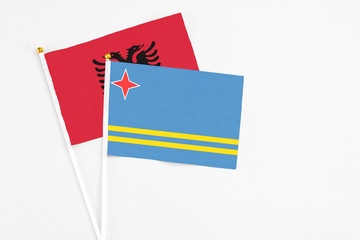 Aruba and Albania stick flags on white background. High quality fabric, miniature national flag. Peaceful global concept.White floor for copy space.