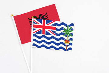 Fototapeta premium British Indian Ocean Territory and Albania stick flags on white background. High quality fabric, miniature national flag. Peaceful global concept.White floor for copy space.