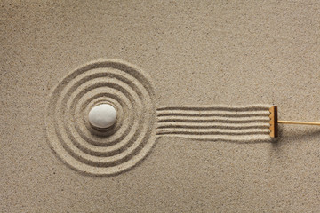 Fototapeta na wymiar A rake in a zen rock garden, preparing the sand. Top view