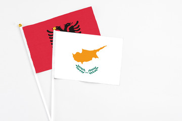 Cyprus and Albania stick flags on white background. High quality fabric, miniature national flag. Peaceful global concept.White floor for copy space.