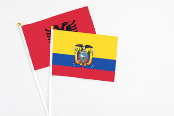 Ecuador and Albania stick flags on white background. High quality fabric, miniature national flag. Peaceful global concept.White floor for copy space.