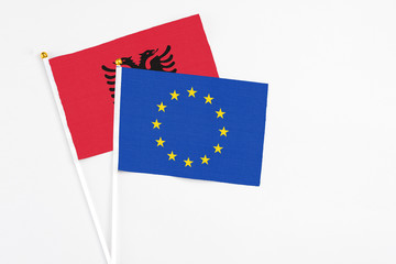 European Union and Albania stick flags on white background. High quality fabric, miniature national flag. Peaceful global concept.White floor for copy space.