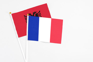 France and Albania stick flags on white background. High quality fabric, miniature national flag. Peaceful global concept.White floor for copy space.