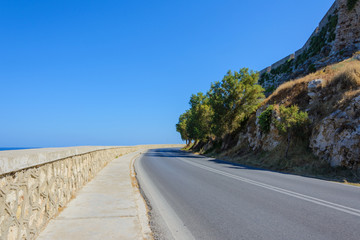turn the highway with a stone parapet under the rock on which stands the fortress of Fortezza. Greece, Crete, Rethymno