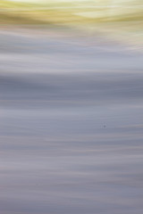 abstract background, blurred foliage in blue like sky, ice, water, photographed with moving camera. Natural bokeh backdrop