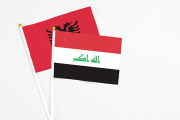 Iraq and Albania stick flags on white background. High quality fabric, miniature national flag. Peaceful global concept.White floor for copy space.