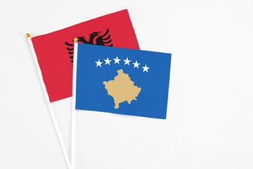 Kosovo and Albania stick flags on white background. High quality fabric, miniature national flag. Peaceful global concept.White floor for copy space.