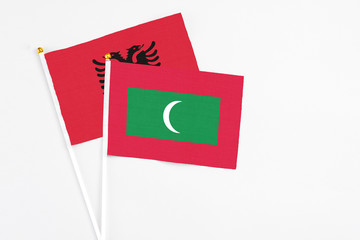 Maldives and Albania stick flags on white background. High quality fabric, miniature national flag. Peaceful global concept.White floor for copy space.