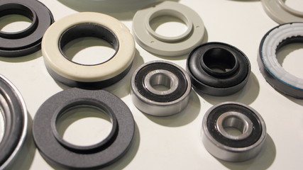 A lot new bearings and o-rings on white background, car parts backdrop texture