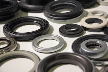 A many new o-rings and bearings on white table, car parts background texture