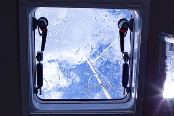 View through a wet yacht hatch on a mast after the rain