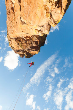 Woman rappels from rock tower in Flatirons above Boulder, Colorado