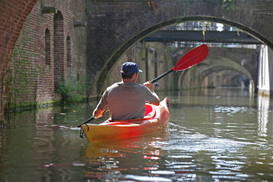 A middle aged man exploring the canals of an old European city