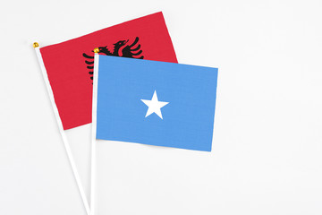 Somalia and Albania stick flags on white background. High quality fabric, miniature national flag. Peaceful global concept.White floor for copy space.