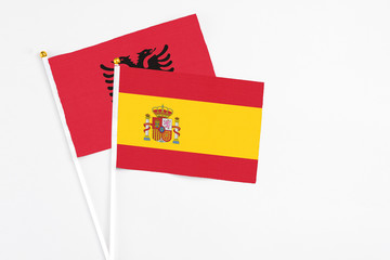 Spain and Albania stick flags on white background. High quality fabric, miniature national flag. Peaceful global concept.White floor for copy space.