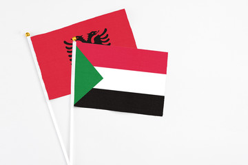 Sudan and Albania stick flags on white background. High quality fabric, miniature national flag. Peaceful global concept.White floor for copy space.