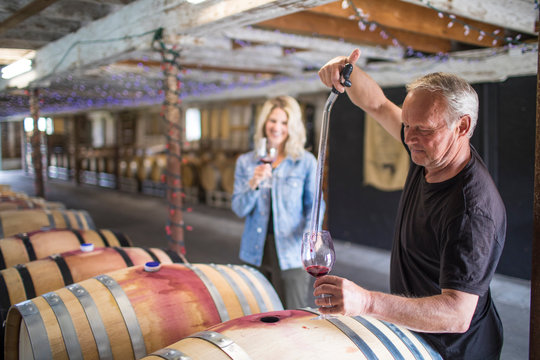 sommelier extracts wine from a barrel during a wine tour.