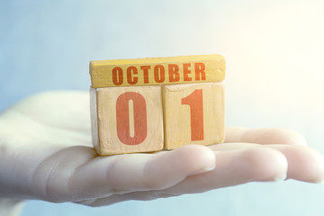 october 1st. Day 1 of month, Handmade wood cube with date month and day on female palm autumn month, day of the year concept