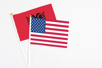 United States and Albania stick flags on white background. High quality fabric, miniature national flag. Peaceful global concept.White floor for copy space.