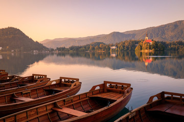 Naklejka na ściany i meble Lake Bled with boats at autumn background. Lake bled is famous place and popular European travel destination.