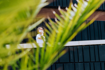 Mature bearded man using a mobile phone while walking on a sunny day