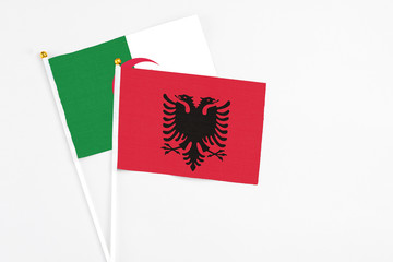 Albania and Algeria stick flags on white background. High quality fabric, miniature national flag. Peaceful global concept.White floor for copy space.