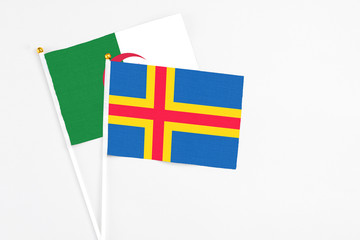Aland Islands and Algeria stick flags on white background. High quality fabric, miniature national...