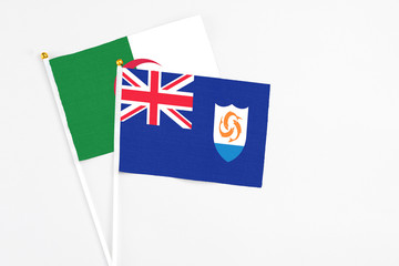 Fototapeta premium Anguilla and Algeria stick flags on white background. High quality fabric, miniature national flag. Peaceful global concept.White floor for copy space.
