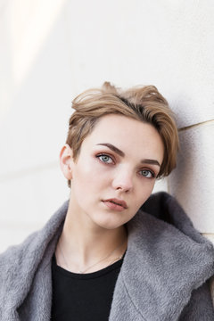 woman with short stylish hairstyle in gray coat