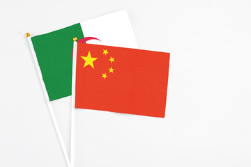 China and Algeria stick flags on white background. High quality fabric, miniature national flag. Peaceful global concept.White floor for copy space.