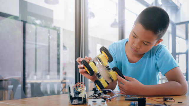 Concentrated boy creating robot at lab.