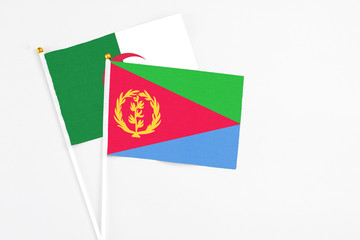 Eritrea and Algeria stick flags on white background. High quality fabric, miniature national flag. Peaceful global concept.White floor for copy space.