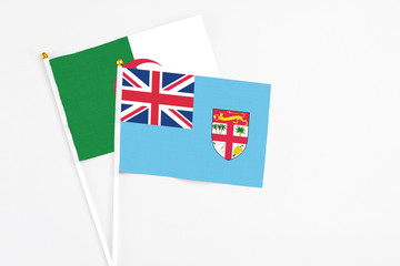 Fototapeta premium Fiji and Algeria stick flags on white background. High quality fabric, miniature national flag. Peaceful global concept.White floor for copy space.